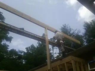 Carpenter setting a ridge beam over a new addition frame — Ice Dam Removal by Roofing Brothers in Elko